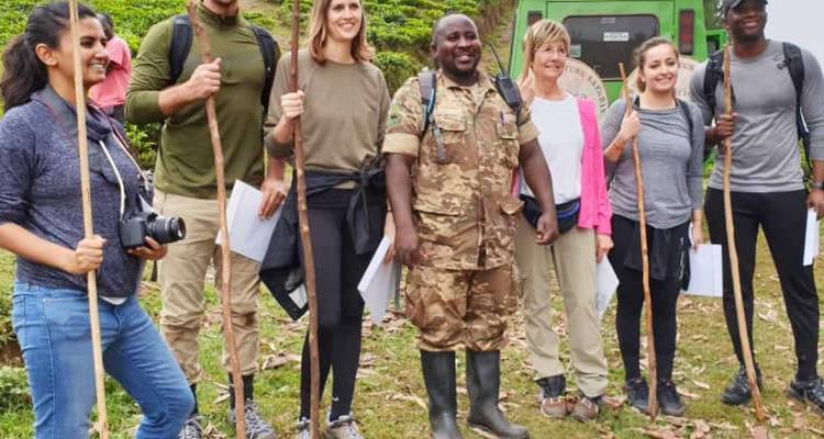 Groep mensen die poseren met wandelstokken in een bosgebied.