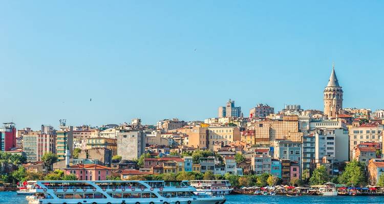 Panoramic view of Istanbul with a ferry on the Bosphorus and Galata Tower.