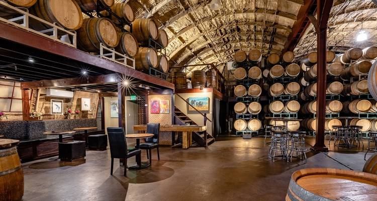 Interieur van een wijnmakerij met vaten langs de muren.