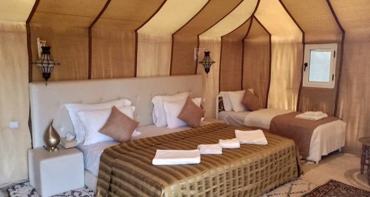 Interior lujoso de tienda con cama grande y decoración ornamental.