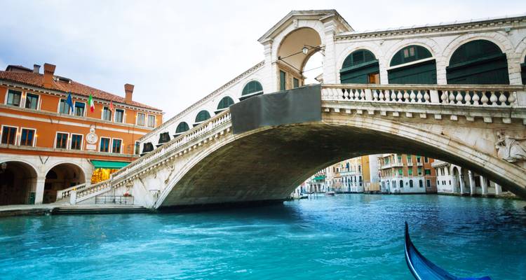 De Rialto Brug spant zich over het Canal Grande van Venetië met turquoise water eronder.