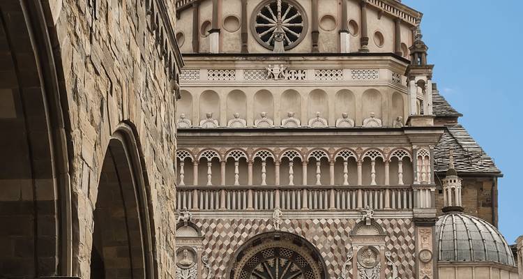 Close-up van Bergamo's sierlijke Cappella Colleoni gevel met ingewikkeld steenwerk en rozet.