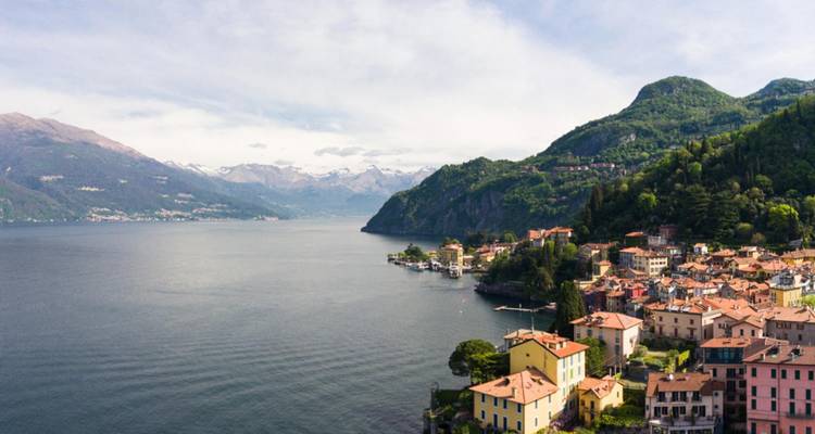 Vista panorámica aérea del Lago de Como extendiéndose entre cordilleras alpinas con pintorescos pueblos a lo largo de la orilla.