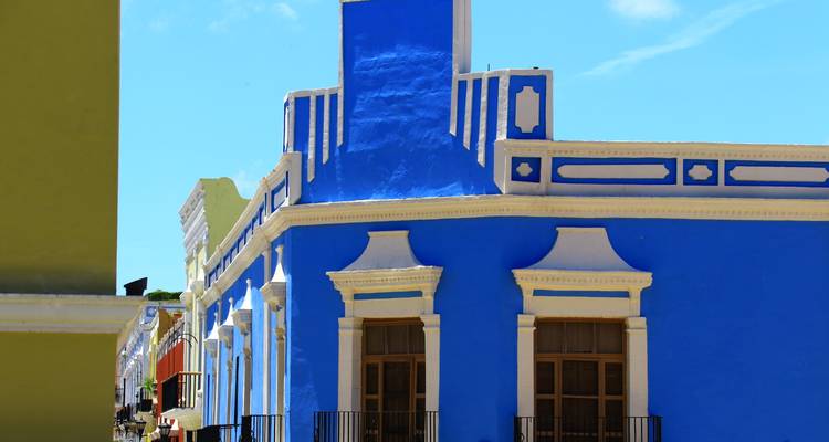 Lebendiges blaues Kolonialgebäude mit Art-Deco-Linien, das sich gegen den klaren Himmel in Campeche abhebt.