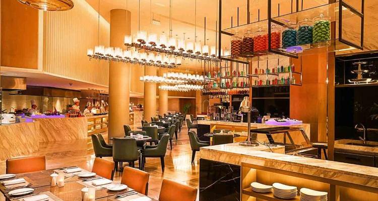 Restaurant interior with modern decor, tables, and colorful overhead lighting.