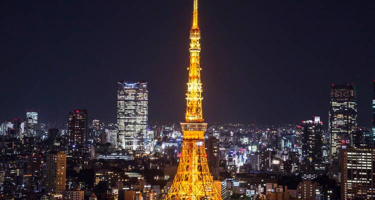 Tokio Tower bei Nacht beleuchtet mit der Stadtsilhouette.