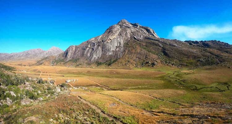 Landscape of rugged mountain terrain under a clear blue sky.