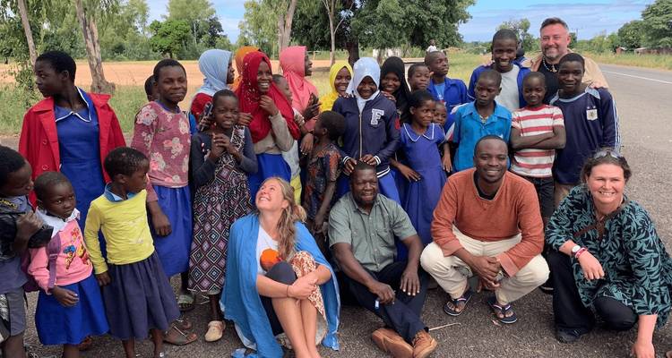 Group of people posing with local children.