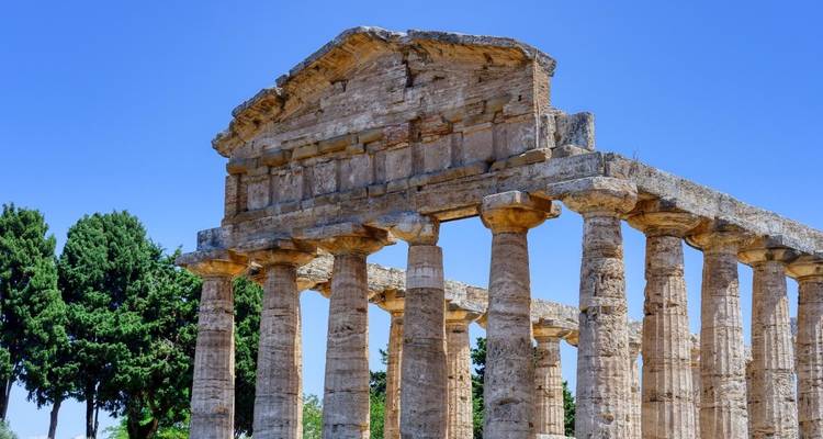 Ruinen eines Tempels im antiken griechischen Stil unter klarem blauen Himmel.