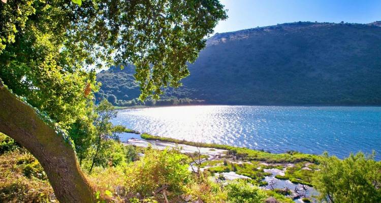 Een schilderachtig uitzicht op een meer omringd door bergen en bomen.