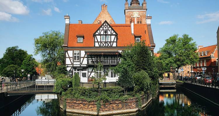 Un bâtiment pittoresque aux toits rouges au bord d'un canal.
