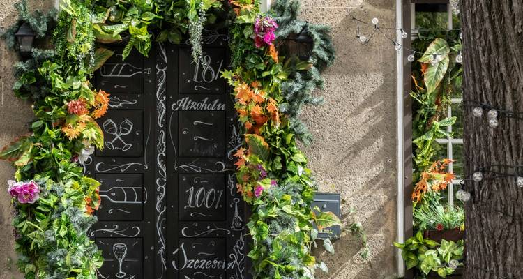 Une porte entourée de verdure et de décorations florales.