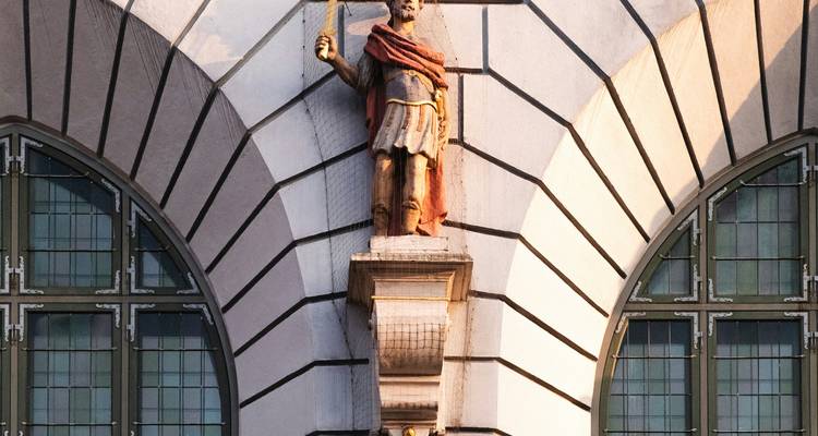 Une statue dans une niche sur la façade d'un bâtiment historique.