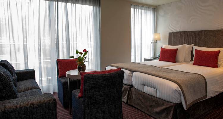 Innenraum einer Hütte mit zwei Betten und einer Sitzecke.