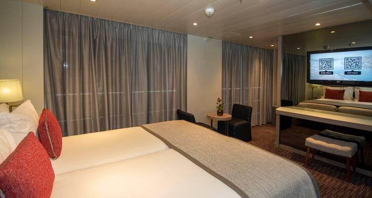 Ein komfortables Kabineninterieur mit einem Fernseher und einer Sitzecke.