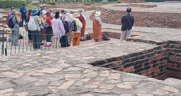 Tour group listening to a speaker at ancient ruins.