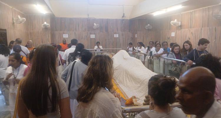 People gathering around a religious figure covered with a cloth.