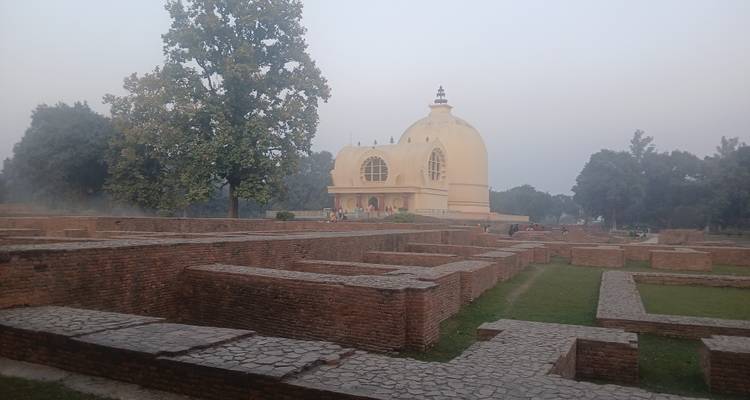 Historic site with a dome-shaped building surrounded by ruins.