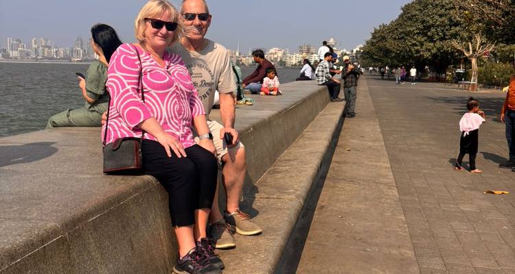 Paar sitzt auf einer Strandpromenade in einer Stadt.