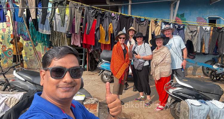 Gruppe macht ein Selfie mit hängender Kleidung im Hintergrund.