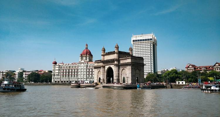 Iconic arch monument on the waterfront of a bustling city.