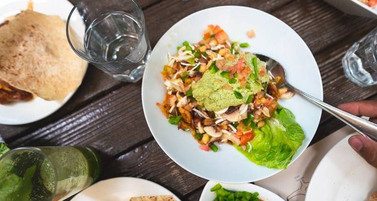 Eine Schüssel mit gemischtem Salat und einem Getränk daneben.