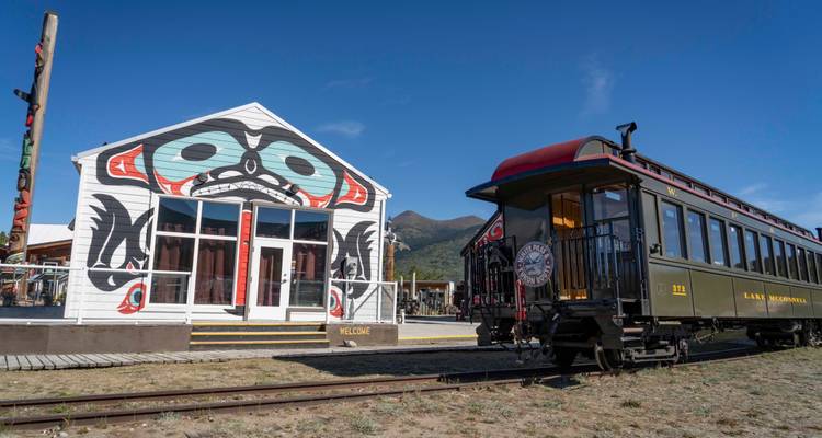 Gare avec art autochtone et train vintage.