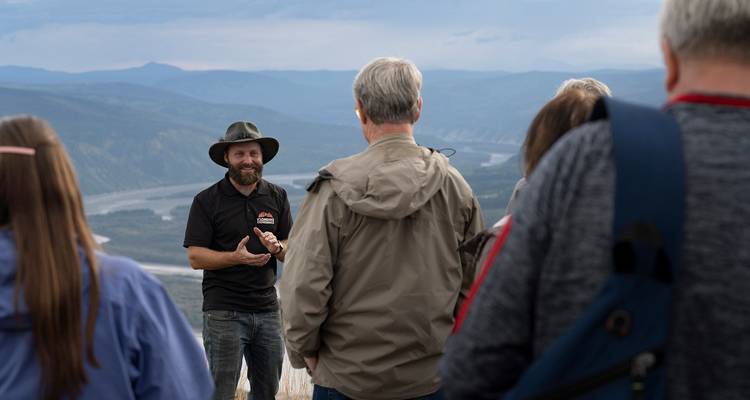 Groupe de personnes écoutant un guide avec vue sur la vallée.
