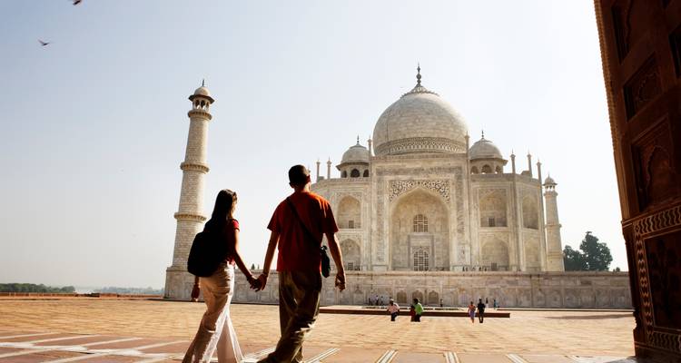 Le Taj Mahal vu avec des personnes qui marchent au premier plan.