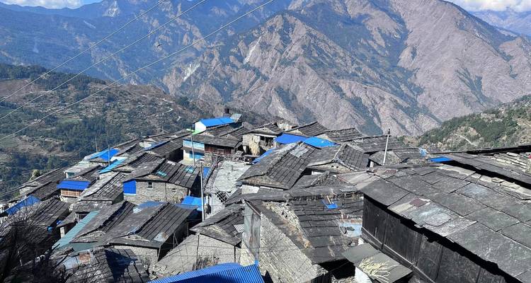 A village with stone roofs set in a mountainous region.