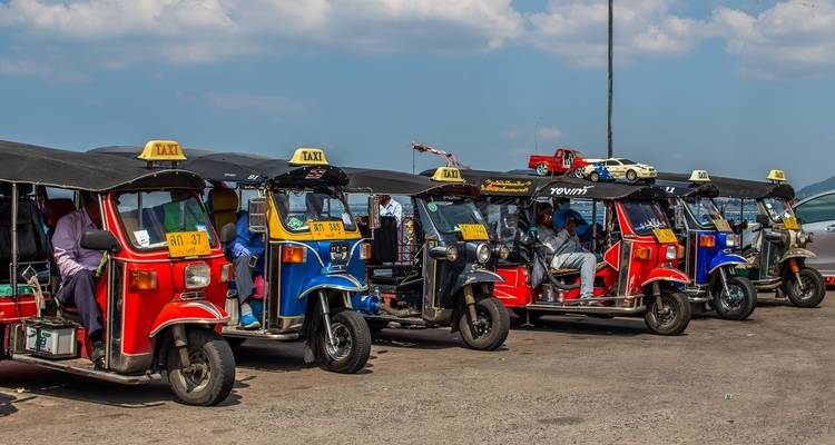 Reihe bunter Tuk-Tuks, die auf der Straße geparkt sind.