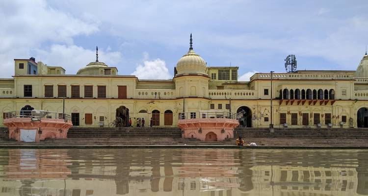 Historic architectural building reflection on water with a bright sky.