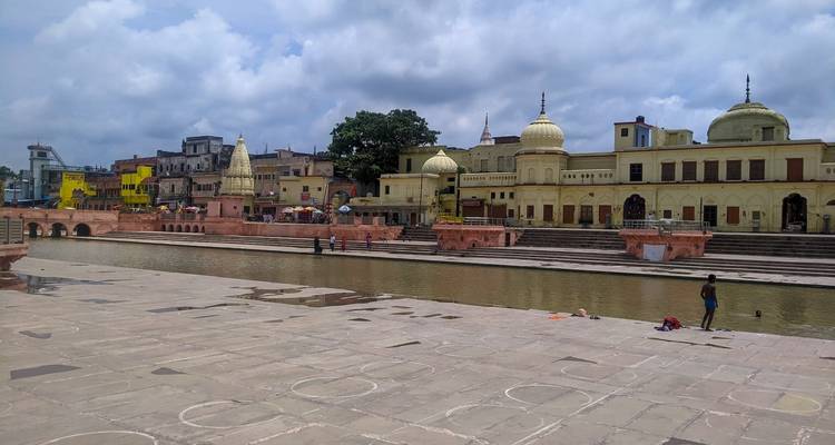 Historic riverside architecture and people visiting the site on a sunny day.