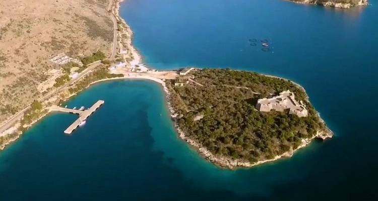 Vista aérea de una pequeña isla con ruinas históricas frente a la costa albanesa.