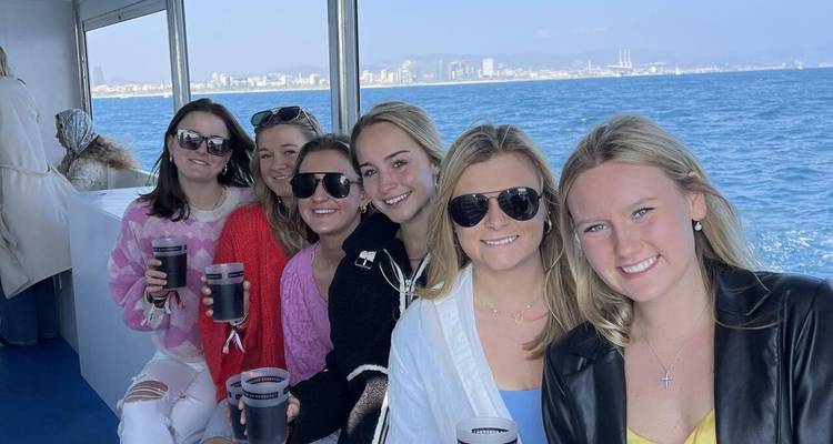 Groupe de femmes sur un bateau tenant des boissons.