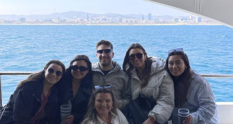 Groupe de personnes sur un bateau avec l'horizon urbain en arrière-plan.