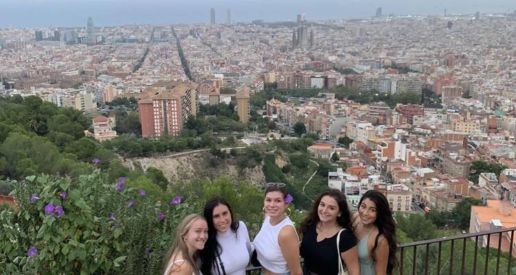 Groupe de femmes posant avec une vue panoramique d'une ville.