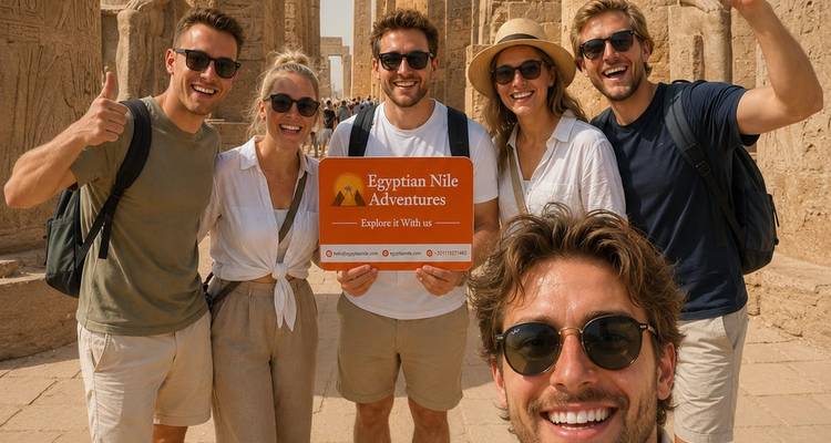 Groupe de touristes prenant un selfie devant des colonnes de grès imposantes dans un temple égyptien.
