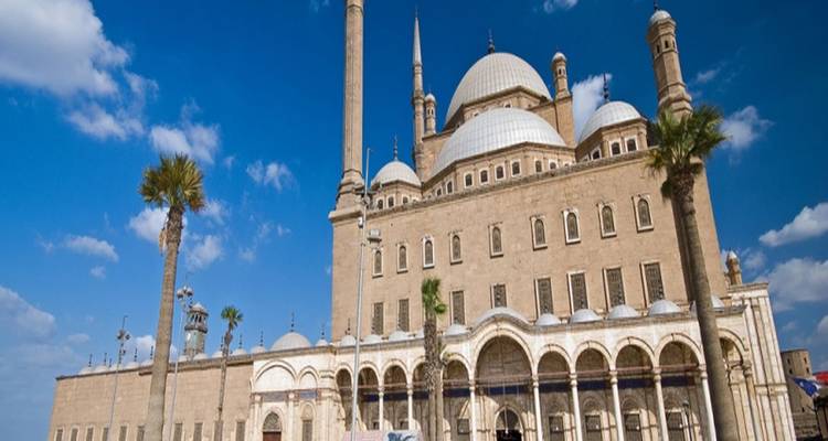 La Mosquée de Muhammad Ali avec ses dômes proéminents et ses minarets sous un ciel bleu éclatant.