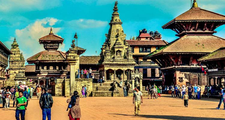 Turistas explorando la Plaza Durbar de Patan con edificios tradicionales.