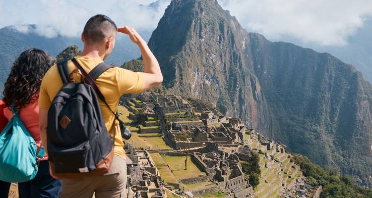 Los viajeros admiran las icónicas ruinas de Machu Picchu desde un mirador panorámico.