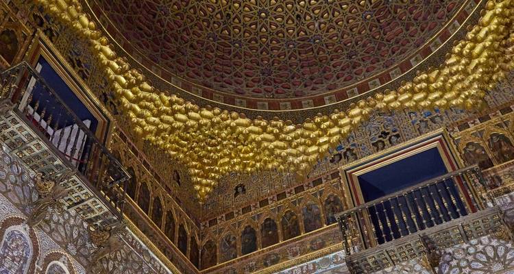 Un plafond doré orné décoré de motifs complexes à l'intérieur du palais Real Alcazar de Séville.