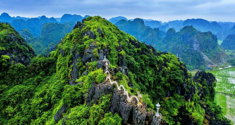 Panoramablick auf einen Bergpfad und die umliegende üppige Landschaft.