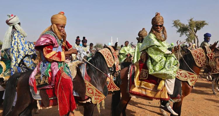 Colorful traditional Nigerian horse riders in an event.