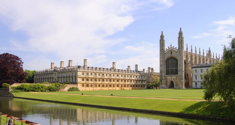 Historical university building by a river.
