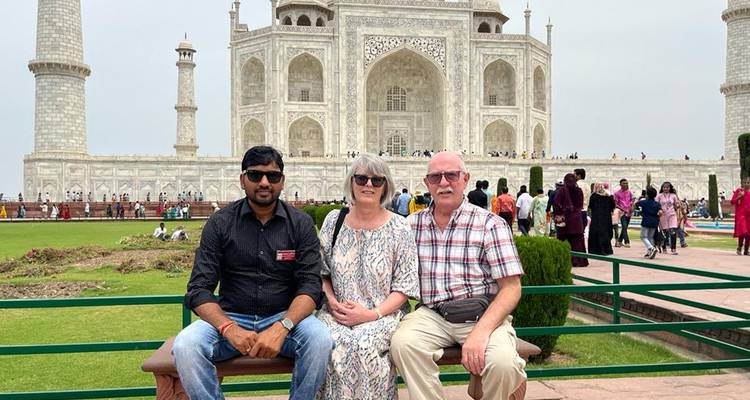 Drei Menschen sitzen vor dem berühmten Taj Mahal