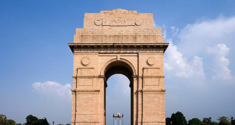 India Gate monument framed against a clear blue sky in New Delhi.