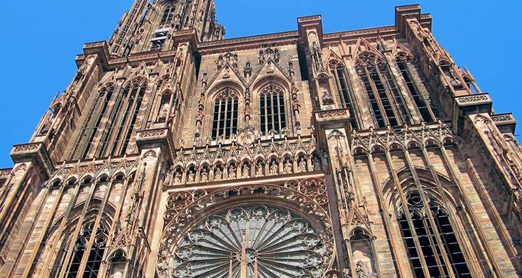 Detailed façade of Strasbourg Cathedral reaching into a bright blue sky.