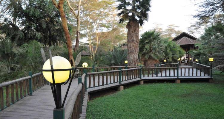 Een wandelpad omgeven door weelderig groen en bomen in een parkachtige omgeving.