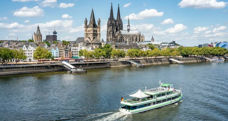 Kölner Dom und Rhein mit einem Kreuzfahrtschiff.